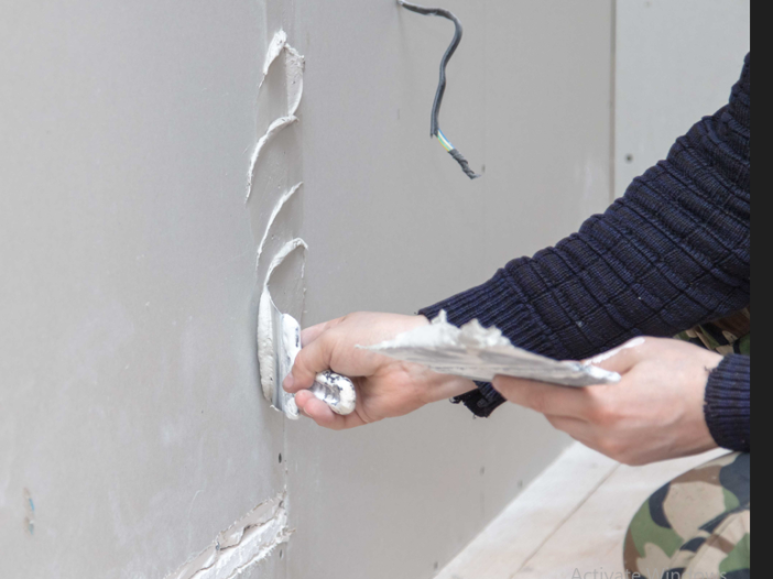 Professional repairing damaged drywall